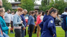 Attendees hold hands during a moment of silence at the vigil on Friday, Aug 16, 2024. (Anisa Vietze/Alaska Public Media)