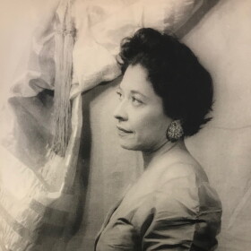 A black and white photo of a woman with short hair facing the left. 