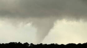 This photo taken by Michelle Vialpando with a smartphone shows a tornado north of Aldea de Santa Fe, N.M., on Saturday, Oct. 24, 2026. The National Weather Service in Albuquerque investigated home damage in Santa Fe over the weekend, ranking the rare tornado as a 'high-end EF1" that produced winds up to 110 mph.