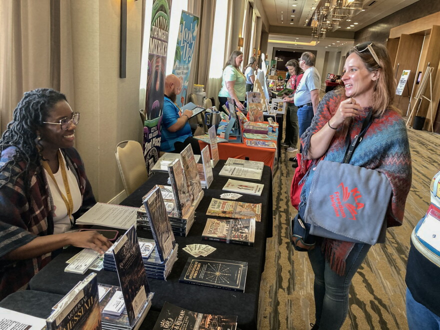 Garicka Hill, left, co-founder of PLPG Publishing, talks with Sammy Herzberg, director of the Oskaloosa Public Library during the Kansas Library Association's annual conference in Wichita.