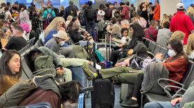 Dr. Anthony Fauci, chief medical adviser to President Biden, cites the U.S. vaccination program and previous widespread transmission of the coronavirus as reasons why the U.S. is not now under pandemic conditions. Here, travelers wait at Miami International Airport last week after mask requirements were lifted.