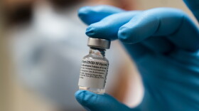 Five doses of the COVID vaccine is held by Spc. Angel Laureano, Monday, Dec. 14, 2020, at the Walter Reed National Military Medical Center in Bethesda Md. 
