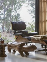 An Eames lounge chair and ottoman sit in the living room.
