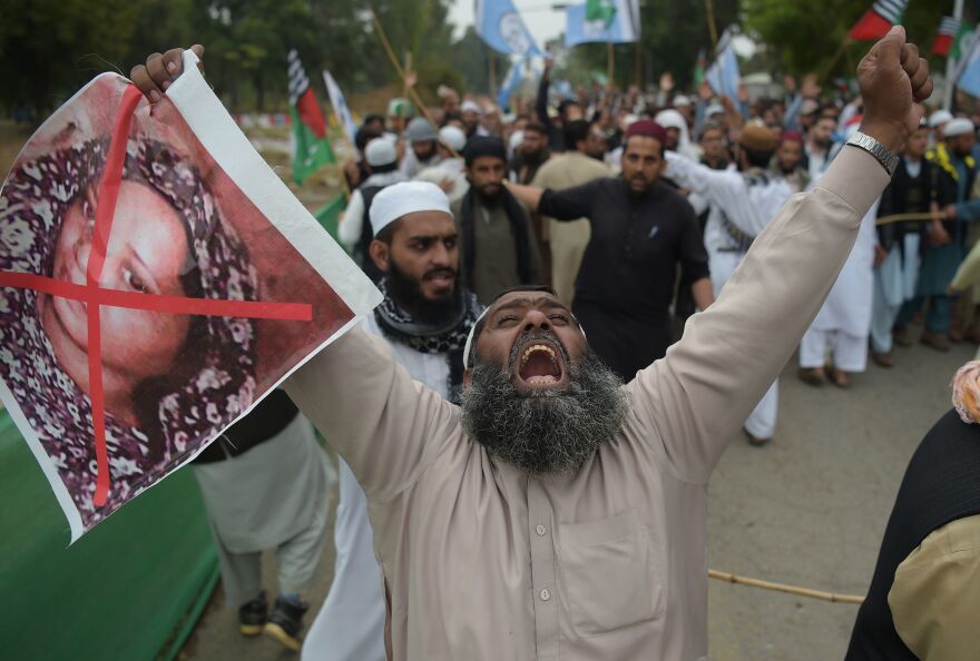 A Pakistani supporter of the Ahle Sunnat Wal Jamaat (ASWJ), a hardline religious party, holds an image of Christian woman Asia Bibi during a protest rally following the Supreme Court's decision to acquit Bibi of blasphemy in Islamabad.
