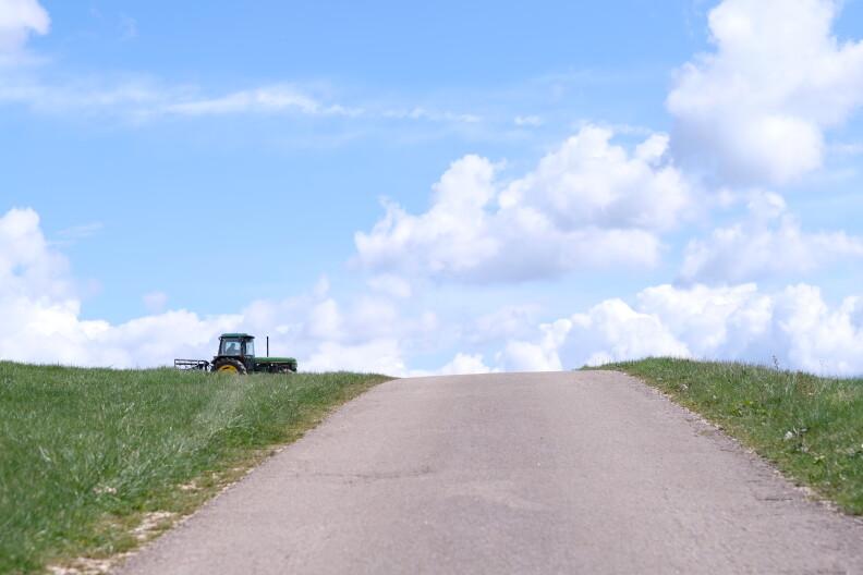 A tractor makes its way towards a road.