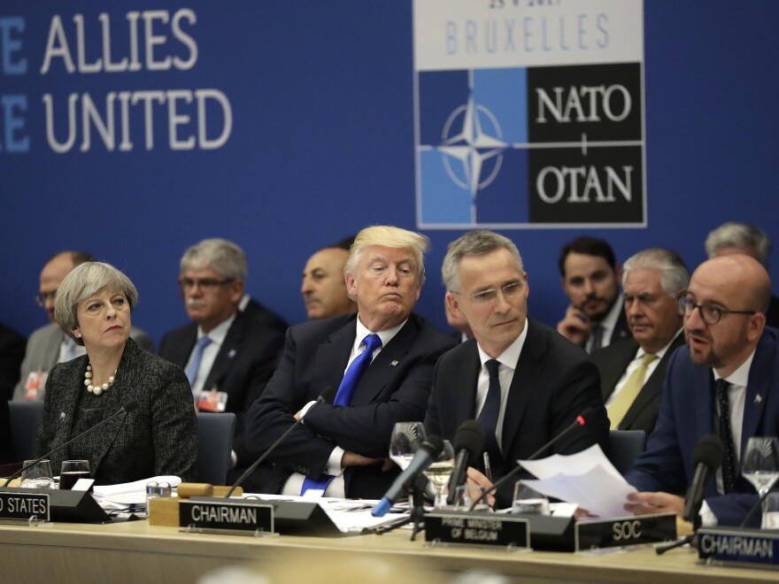 British Prime Minister Theresa May, U.S. President Donald Trump and NATO Secretary General Jens Stoltenberg listen to Belgian Prime Minister Charles Michel as he speaks during a working dinner meeting at the NATO headquarters during a NATO summit of heads of state and government in Brussels on May 25, 2017.