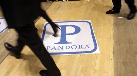 Traders on the floor of the New York Stock Exchange walk over insignia for Pandora Media Inc., the online-radio company, on its first day of trading as a public company on June 15, 2011 in New York City. (Spencer Platt/Getty Images)