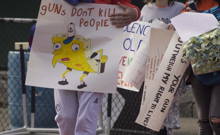 Students at Ridgefield High School hold posters and signs as they participate in the National School Walkout on April 20, 2018. Students at Ridgefield organized the walkouts nationwide.