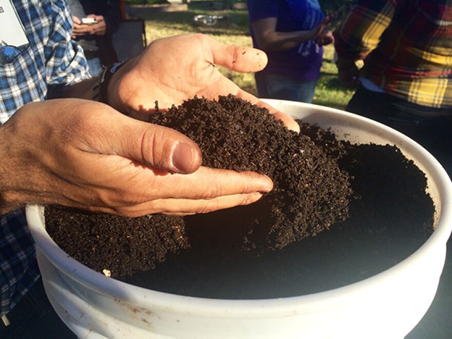 Chris Cano digs his hands into a bucket of finished compost. “It’s incredibly soft and fluffy, he said. “And this was once food waste. I’m still shocked to this day when I touch this and just think that this was bound for the garbage.”