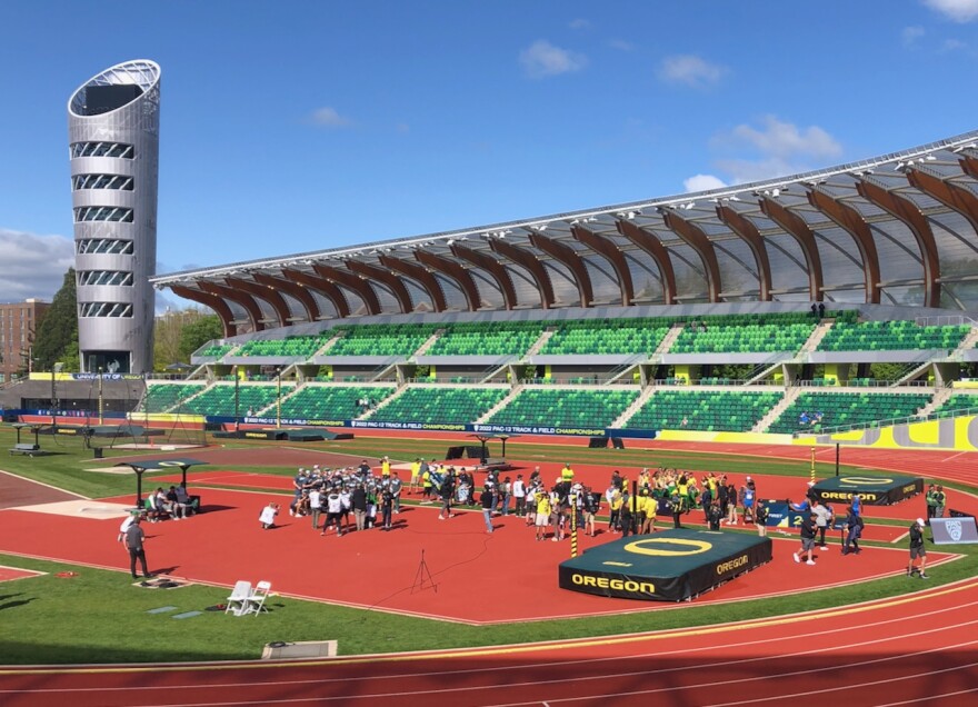 The Duck men, left, and women gather on the field to accept their trophies for the 2022 Pac-12 championships