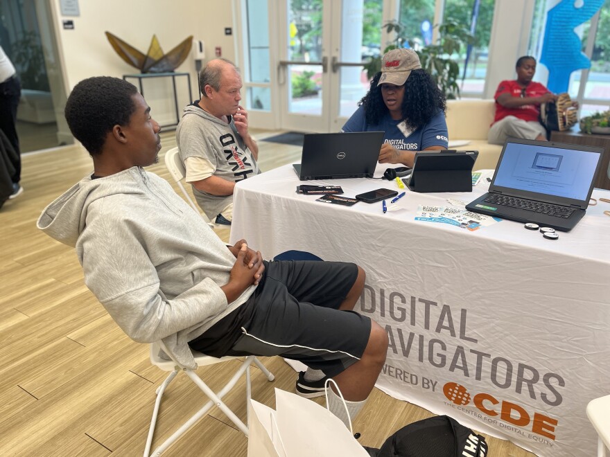 Community members gather at Queens University of Charlotte to receive laptops distributed by the Center for Digital Equity through a partnership with AT&T and the group Human I-T.