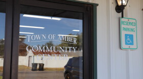 A glass door on a white metal building. The door reads "Amber Community Center."