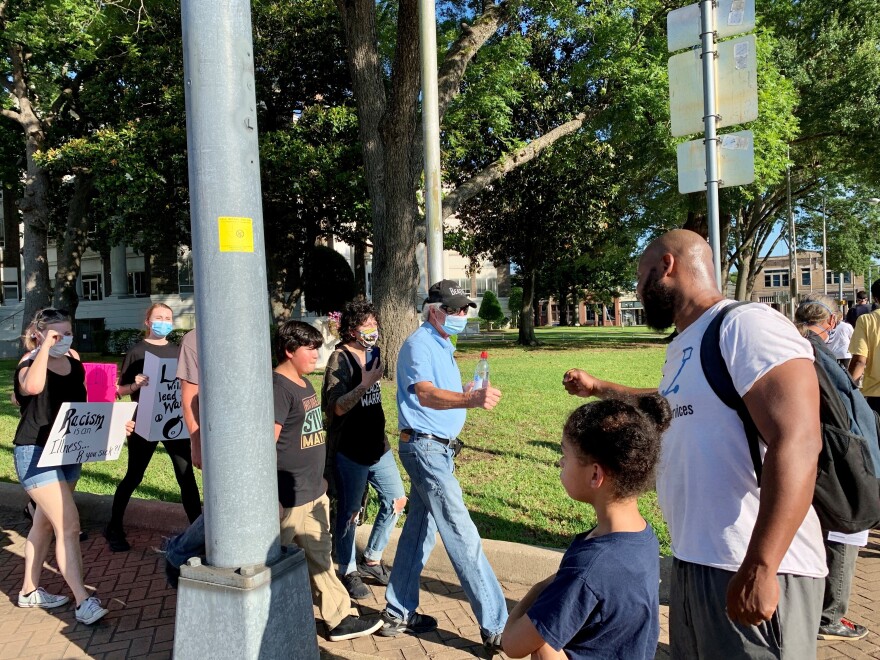 Walter Lundy fist-bumps a protester at the Henderson County courthouse in Athens, Texas.<strong></strong>