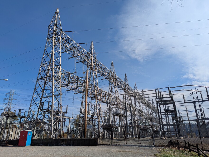 A large electrical station with blue skies above.