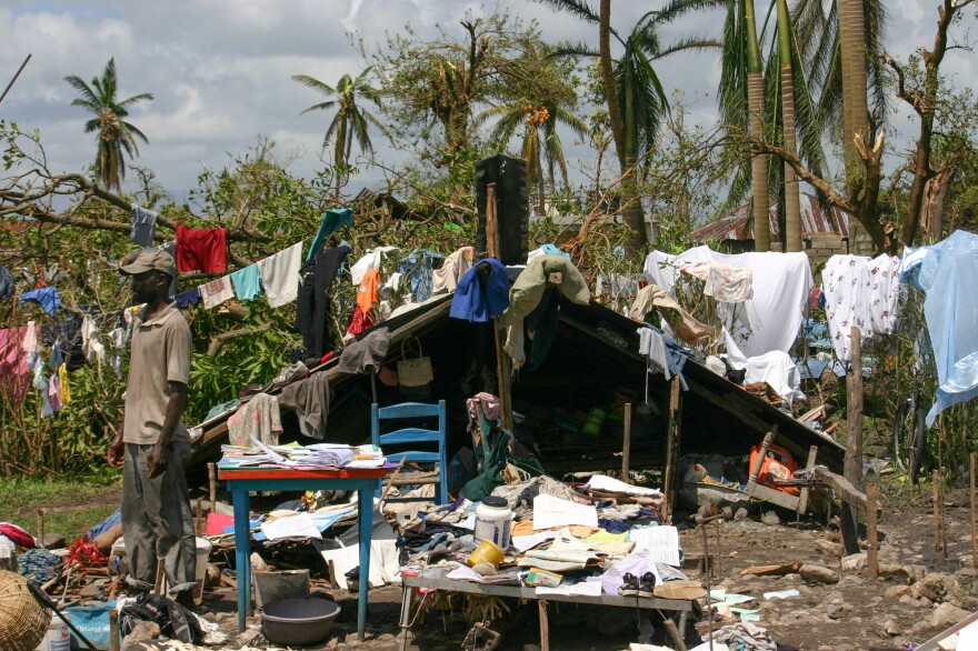 Gilbert Lorcy outside his home in Les Cayes. He was able to put the roof — which blew off in the storm — on the low stone walls of the foundation. His family spends days at the house and sleeps in a shelter at night.