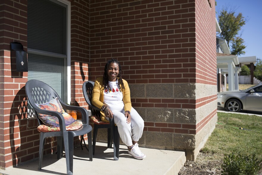 Mary Harris poses outside her new townhouse in Pine Lawn. Nonprofit group Beyond Housing built dozens of affordable homes in the area using a low-income housing tax credit.