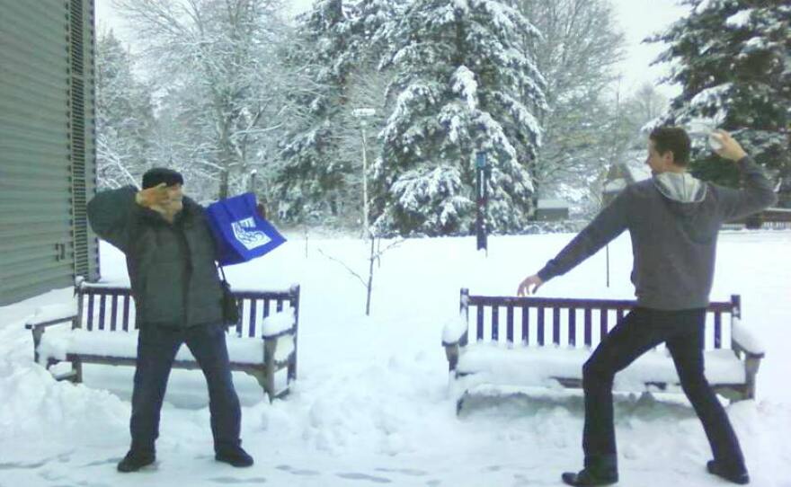 KPLU host Kevin Kniestedt takes aim with a snowball as Dick Stein takes refuge behind the KPLU tote bag.