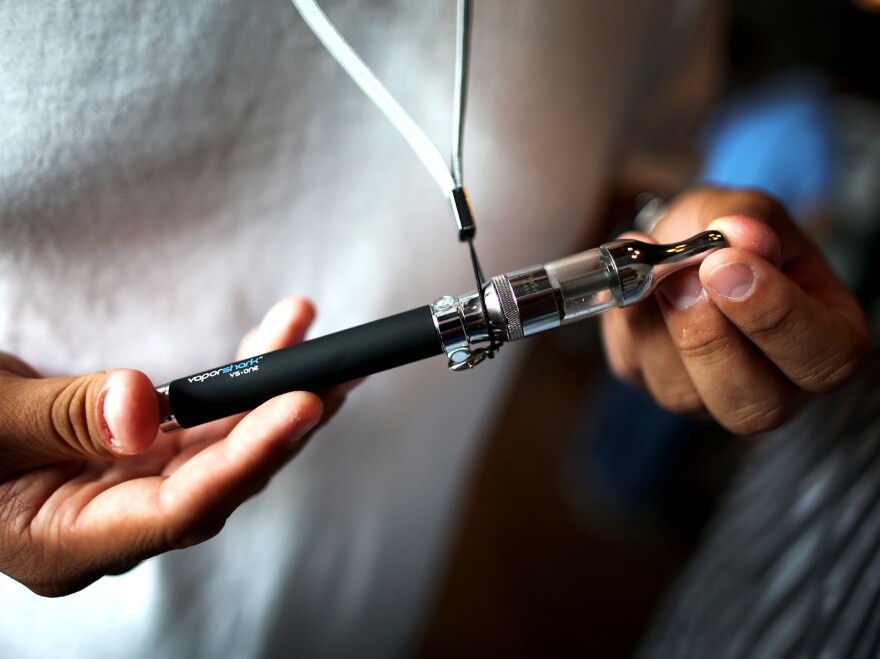 A customer holds the electronic cigarette he purchased at a store in Miami.