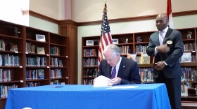Ferguson-Florissant schools superintendent Joseph Davis watches as Gov. Jay Nixon vetoes a measure that would have changed the state's school funding formula on May 4, 2016.