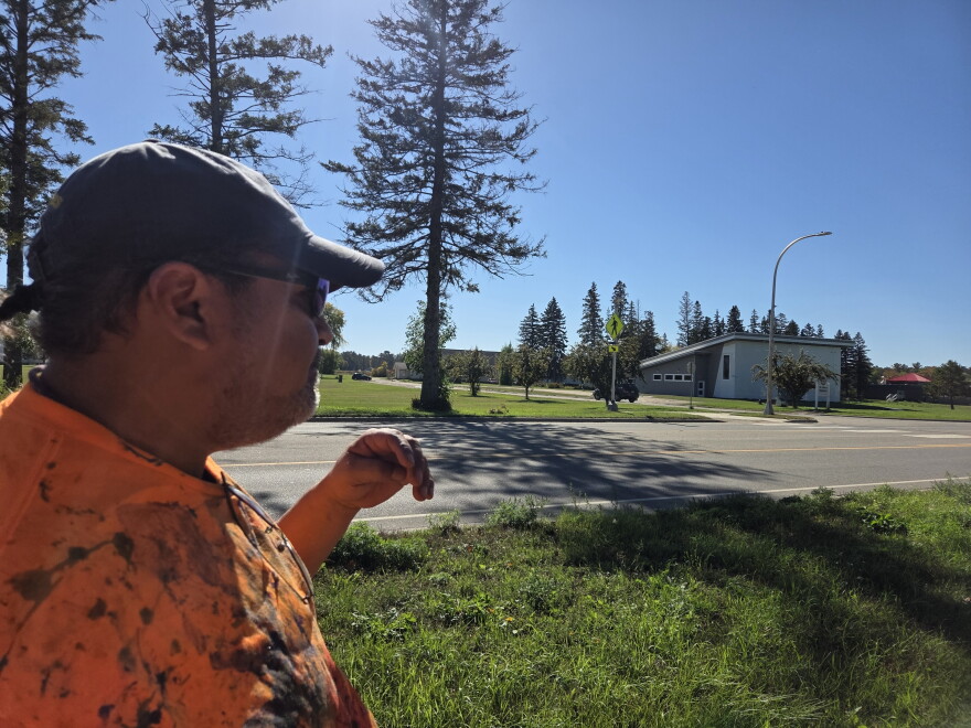 Donovan May, a sixth grade instructor at Red Lake's charter school, indicates the area where St. Mary's boarding school used to be on Sept. 30, 2026.