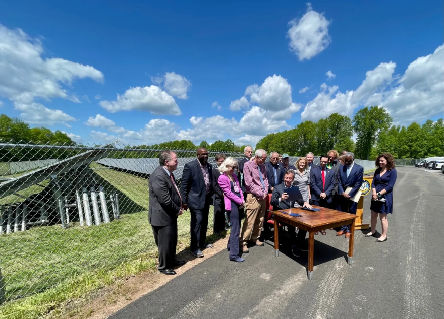 A solar array outside the Bloomfield Board of Education was the backdrop for Gov. Ned Lamont's ceremonial bill signing.