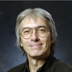 T. Crunk with gray hair wearing glasses and a black shirt
