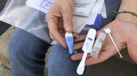 Solutions Oriented Addiction Response organizer Brooke Parker displays an HIV testing kit in Charleston, W.Va., on March 9, 2021.