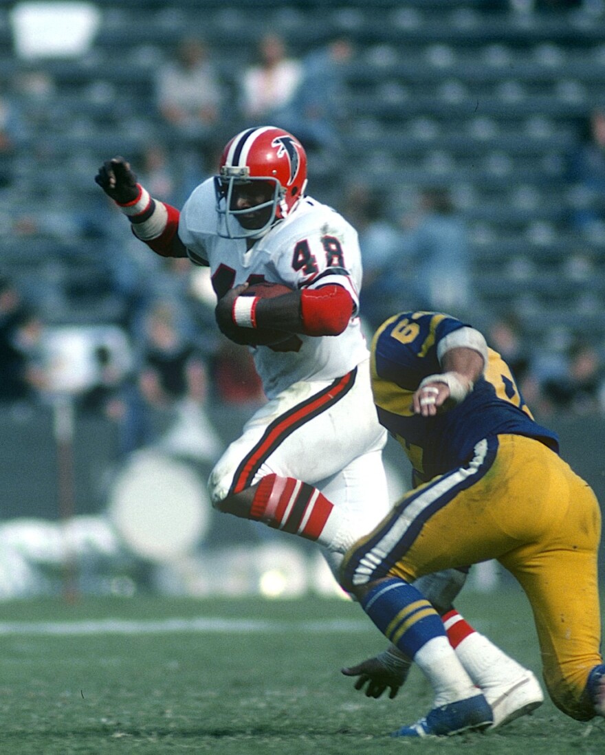 Falcons running back Woody Thompson evades a Los Angeles Rams defender in 1975 before a sparse crowd