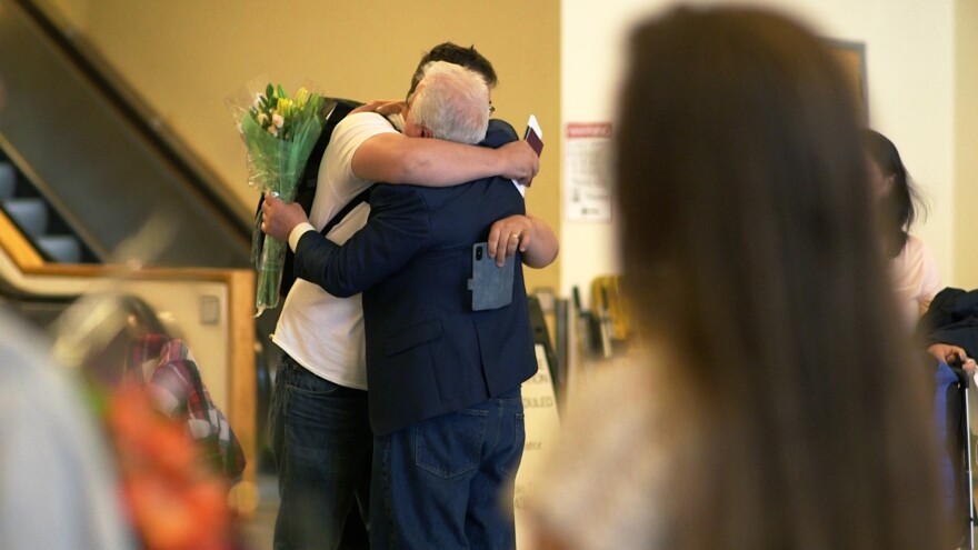 A Ukrainian man embraces a loved one upon arriving at Ted Stevens International Airport on Saturday, May 21, 2022. (Shiri Segal/Alaska Public Media)