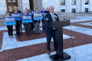 Independent gubernatorial candidate Ken Block speaks at a news conference outside the Rhode Island State House in Providence on Monday, Oct. 26, 2026, as supporters stand behind him. Block outlined 17 policy priorities and pledged not to undermine the Affordable Care Act if elected governor. Credit: Ian Donnis/Ocean State Media