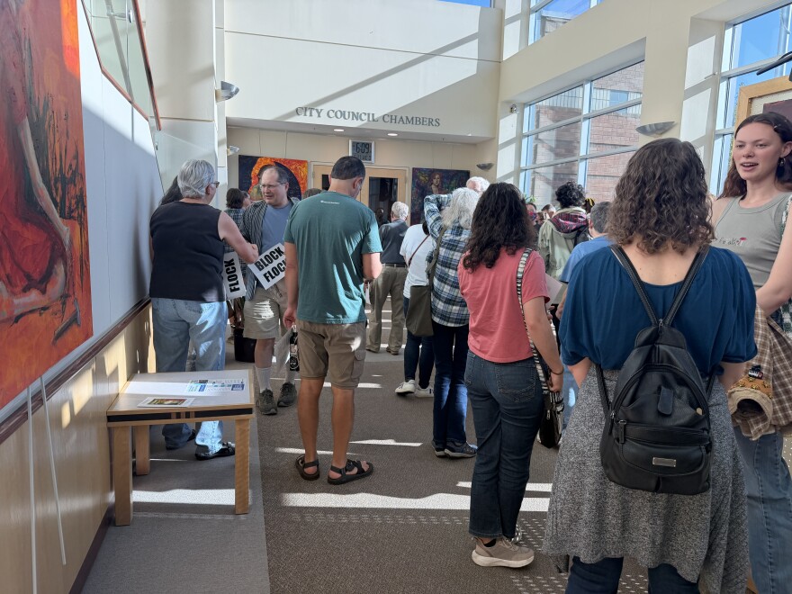 Residents gather outside of Albany City Counsel Chambers holding "Block Flock" signs before the meeting, May 27, 2026.