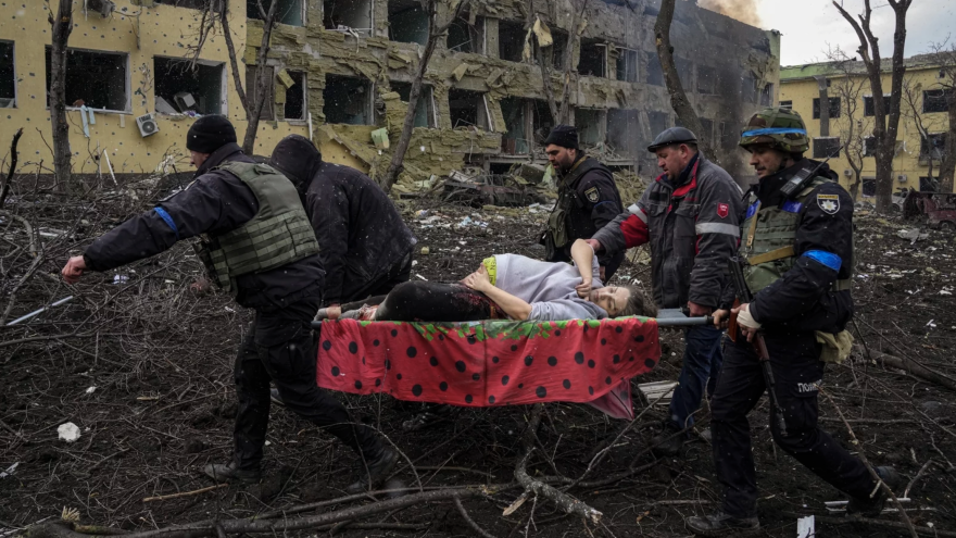 Ukrainian emergency workers and volunteers carry an injured pregnant woman from a maternity hospital damaged by an airstrike in Mariupol, Ukraine, on March 9, 2022. The woman was taken to another hospital but did not survive.