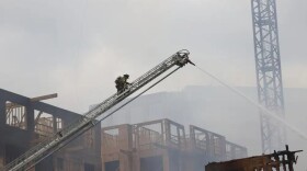 Firefighters work the scene of a massive fire spread across at least two structures and threatened others in Charlotte's South Park neighborhood, North Carolina, Thursday morning, May 18, 2023.