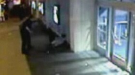 Grainy surveillance video captures the moment a King County Sheriff's deputy, working with Metro Transit police, knocks Christopher Harris against an outside wall of the Cinerama Theater in Seattle's Belltown neighborhood in May 2009.