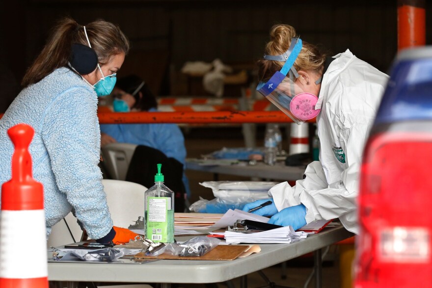 Registered nurses Geri Taylor, left, and Joni Phelps, go through paperwork at a mobile testing site for COVID_19 at the Murray County Expo Center in Sulphur, Okla., Tuesday, April 14, 2020.