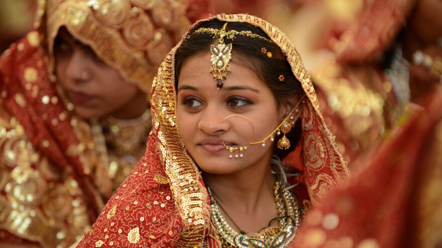 An Indian bride at a mass wedding. Whether Hindu, Christian, Buddhist or Muslim, bedecking an Indian bride in gold is believed to invest her with good fortune.