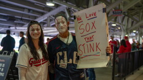 Fans in makeup with a sign that reads "We love sox that stink."