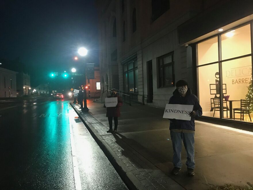 Barre residents stand silently with homemade signs as a counter-protest to a Trump rally going on across the street.