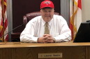 Judge Layne Smith wears a ball cap and sits in his courtroom, smiling for the camera