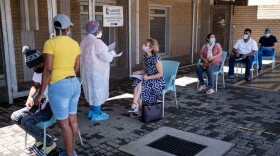 A health care worker speaks with a woman queuing for a PCR COVID-19 test in Johannesburg on Nov. 30, 2021. A new, heavily mutated COVID-19 variant named omicron spread across the globe on Sunday, shutting borders and renewing curbs. (Emmanuel Croset/AFP/Getty Images)