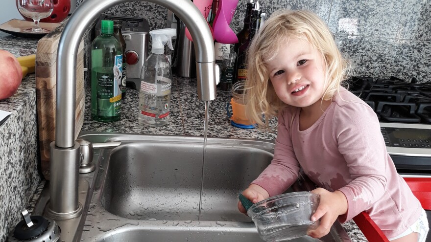 Our correspondent Michaeleen Doucleff's daughter, Rosy, at age 2, as she does dishes voluntarily. Getting her involved in chores did lead to the kitchen being flooded and dishes being broken, Doucleff reports. But Rosy is still eager to help.