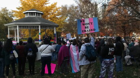 A protestor hods a sign that reads "We won't be erased" at a rally in Goodale Park on Wednesday.
