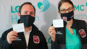  Dr. Joseph Kanter and Dr. Jennifer Avegno hold up their vaccination cards after receiving their shots at University Medical Center in New Orleans. Dec. 15, 2020.