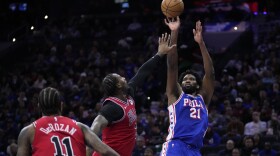 Philadelphia 76ers' Joel Embiid, right, goes up for a shot against Chicago Bulls' Andre Drummond, center, during the first half of an NBA basketball game, Tuesday, Jan. 2, 2024, in Philadelphia. (AP Photo/Matt Slocum)