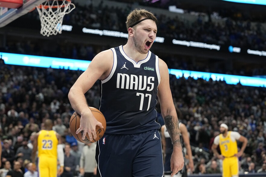 Dallas Mavericks guard Luka Doncic yells on the court with the ball in his hand.