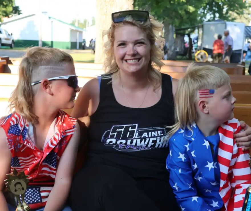 Hairstylist Katie Selfridge poses between contestants Reed Moszer (left) and Paul Maier | MPR News
