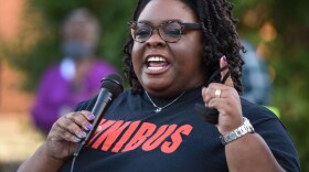 A woman speaks into a microphone at a protest