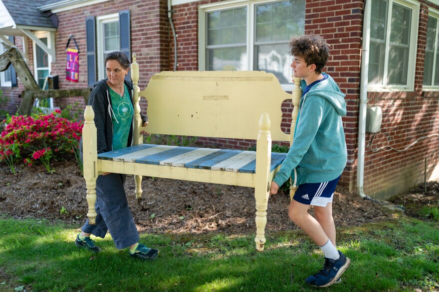 Jenna Fournel and Leal Abbatiello, 14, carry a daybed frame to display their produce at their home in Alexandria, Va. on April 30, 2022.