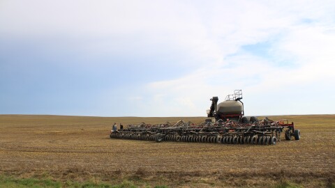 Farmer Justin Miller [right] takes over seeding duties from his colleague on a farm near Gildford, MT on Sept. 12, 2025. Miller is seeding next year’s winter wheat, despite historically low commodity prices.