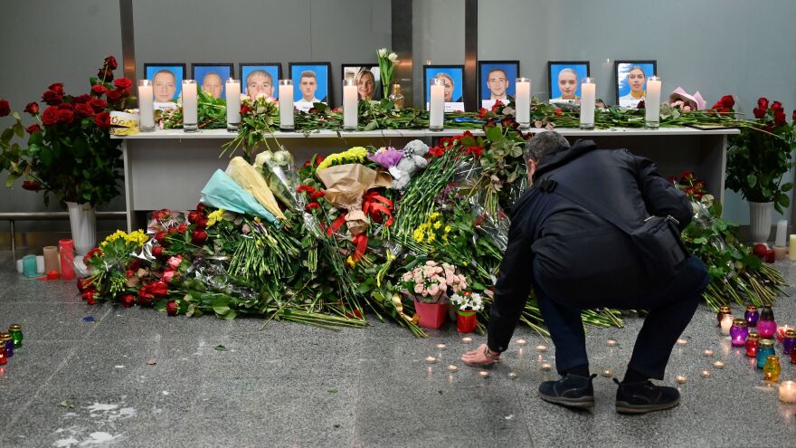 A man contributes to a memorial for the crash victims set up Wednesday at the airport outside Ukraine's capital, Kyiv. Among the 176 victims aboard the plane were 82 Iranians, 63 Canadians and 11 Ukrainians.